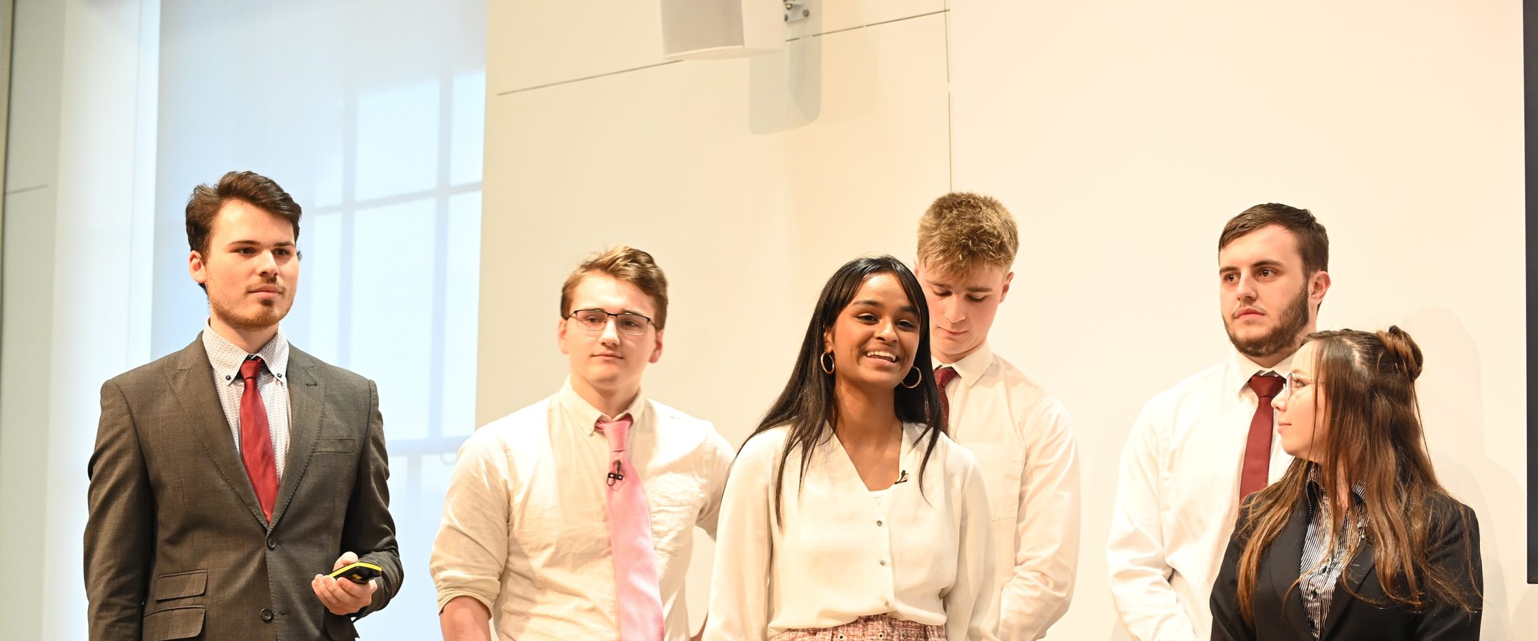 Group of 6 students presenting on a stage