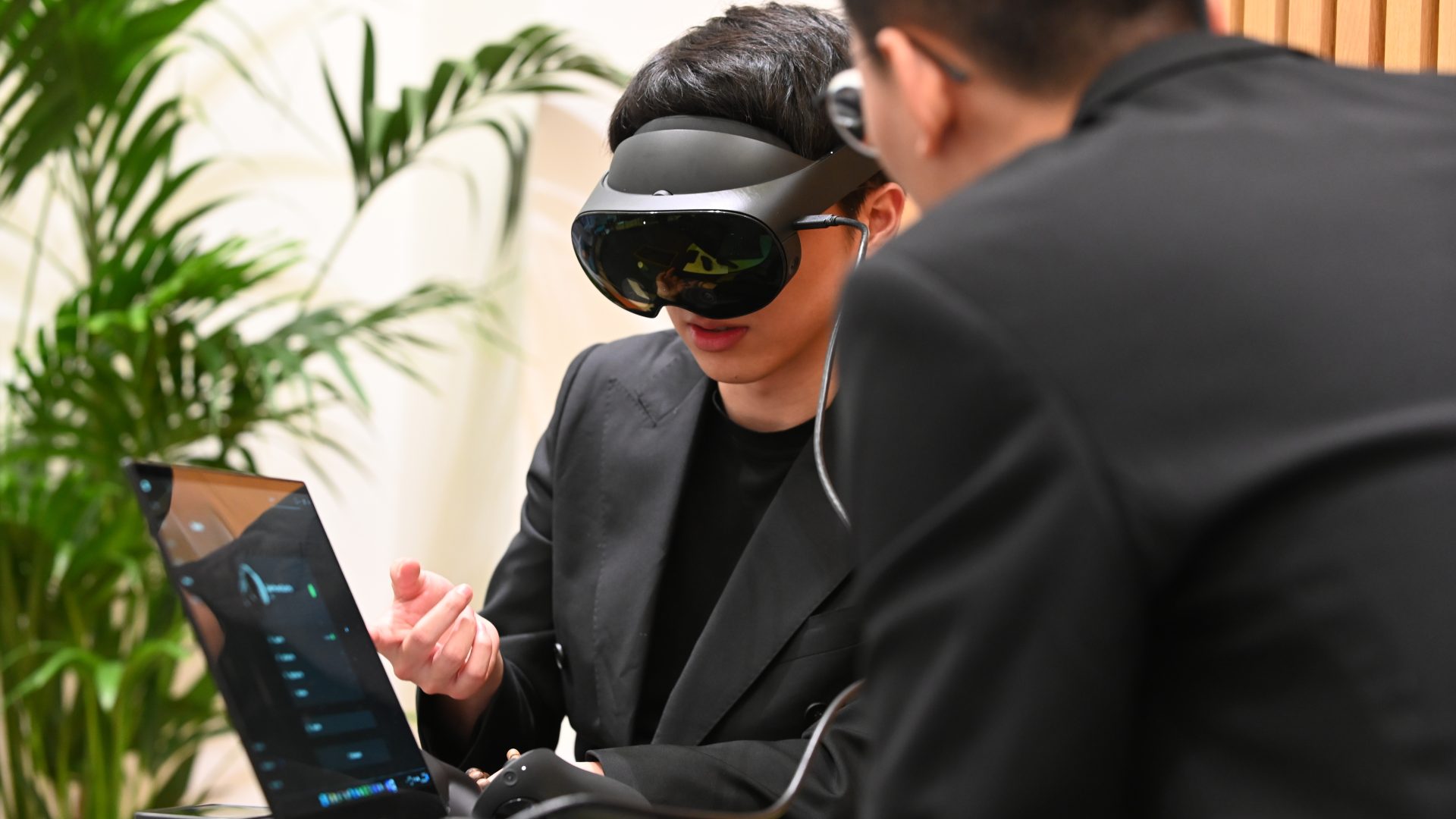 A person wearing a vr headset pointing at a screen